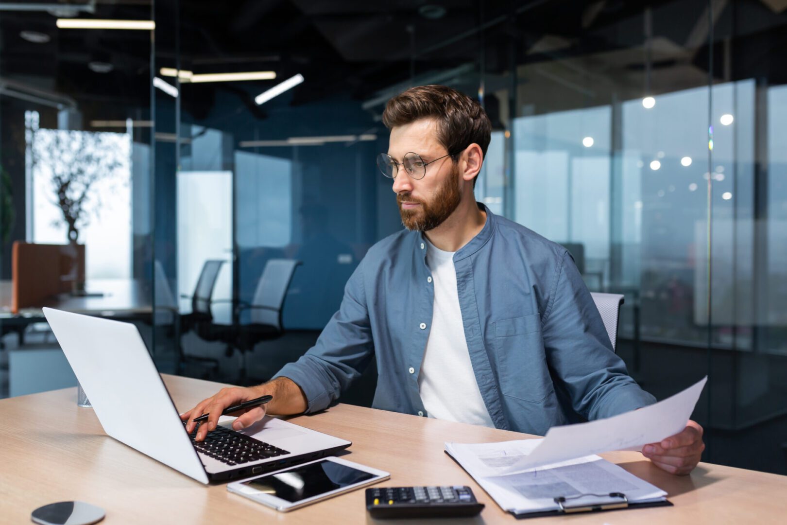 Man working at desk with laptop.