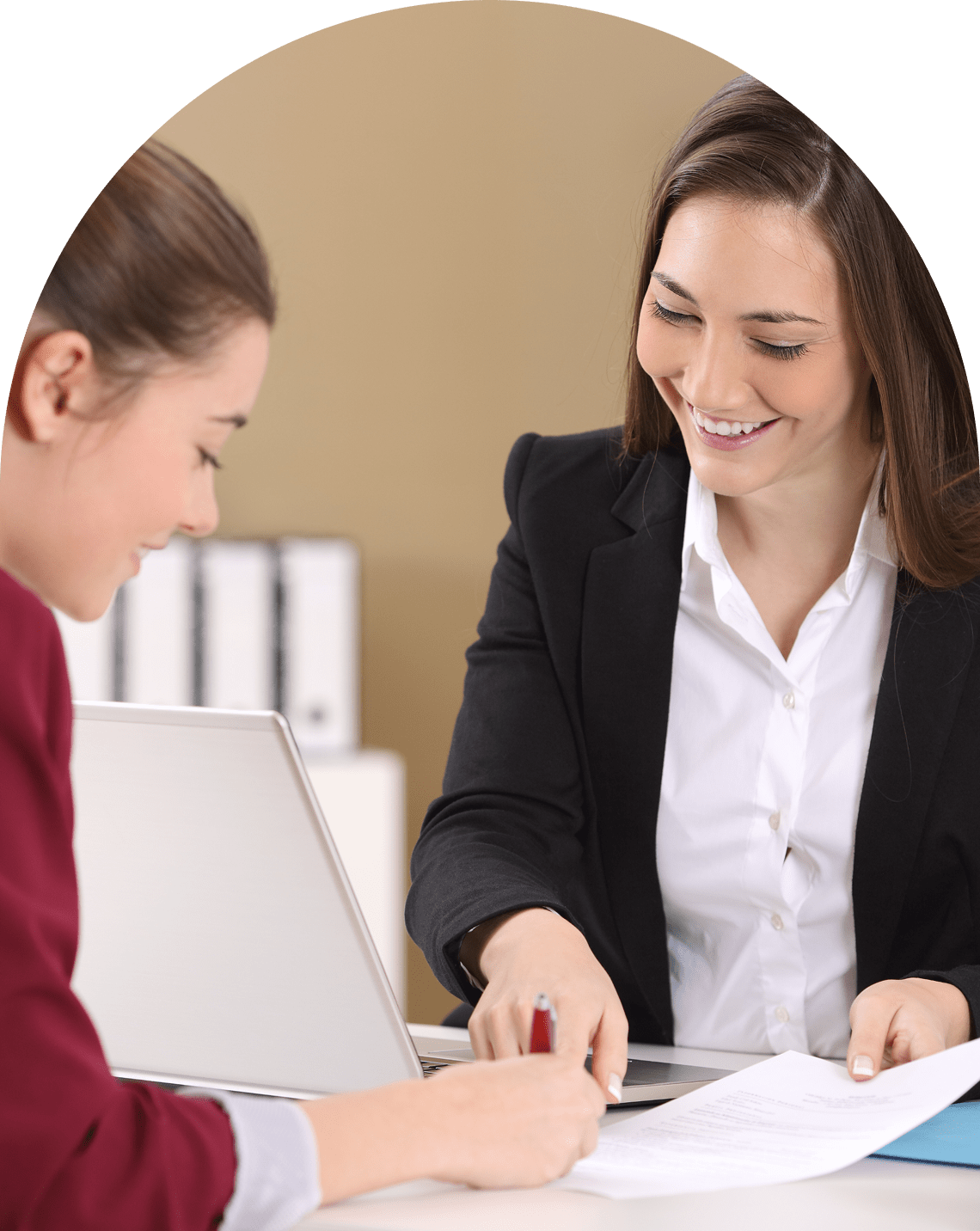 Two women discussing documents in office.