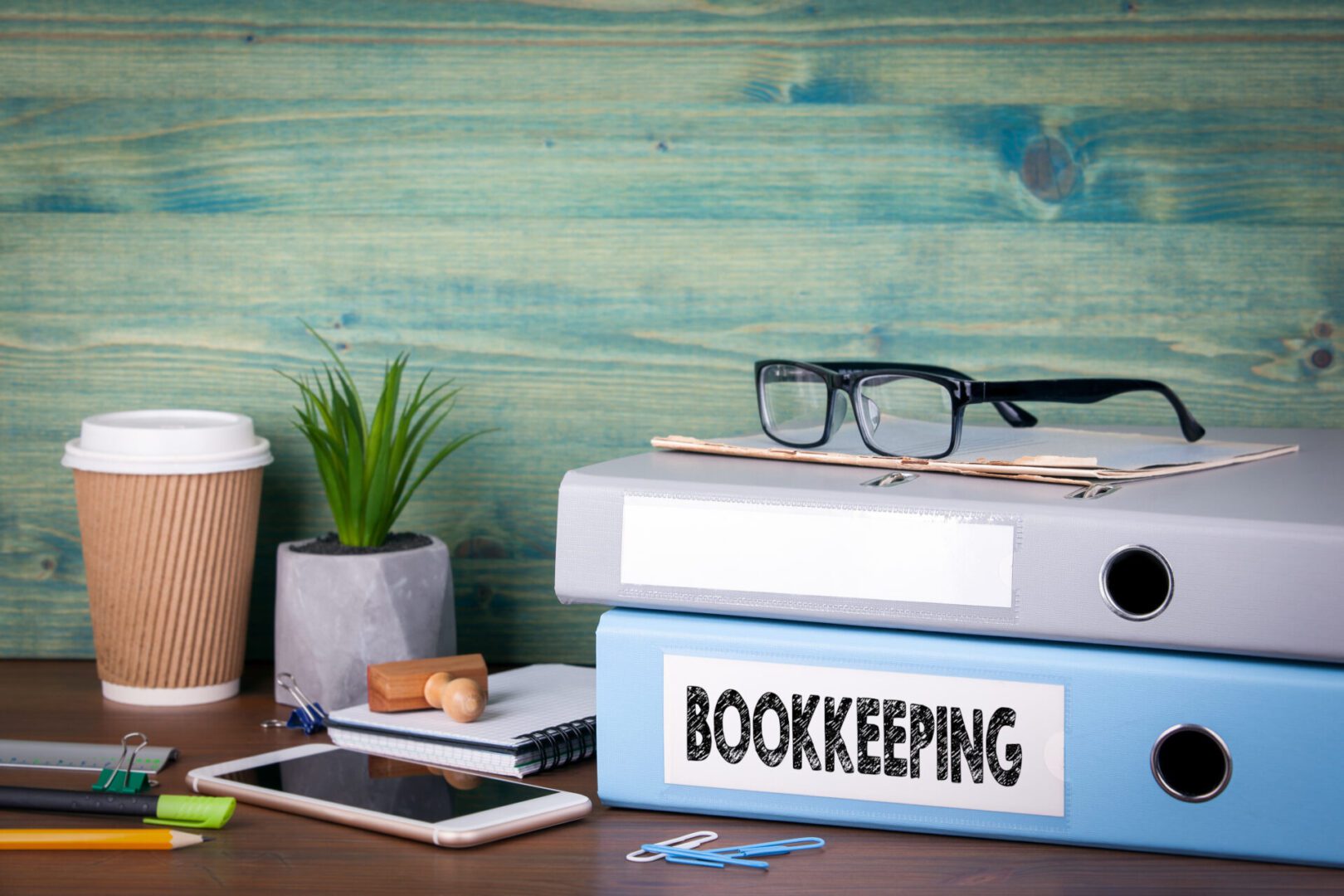 Bookkeeping folders on desk with office supplies.